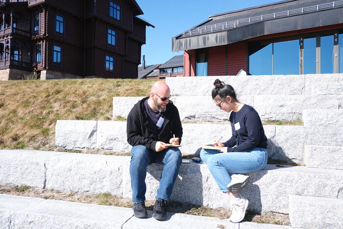 Maximilian Wess and Jingwen Ding brainstorm their idea outside in the sun.