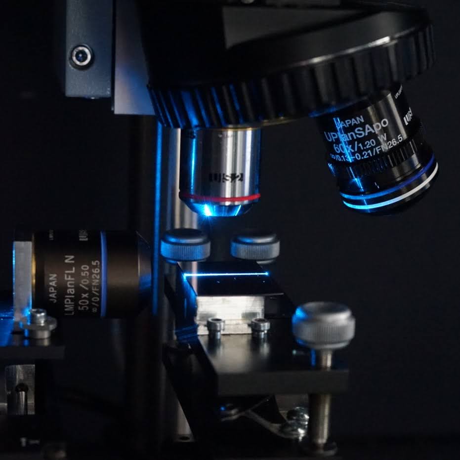 Close-up picture of a black microscope and a glass sample plate